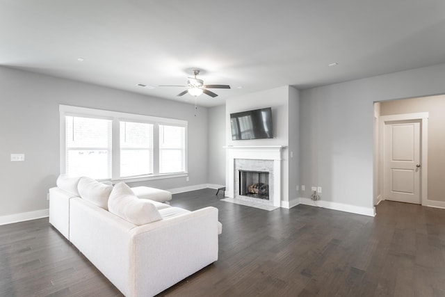 living room featuring ceiling fan and dark hardwood / wood-style flooring