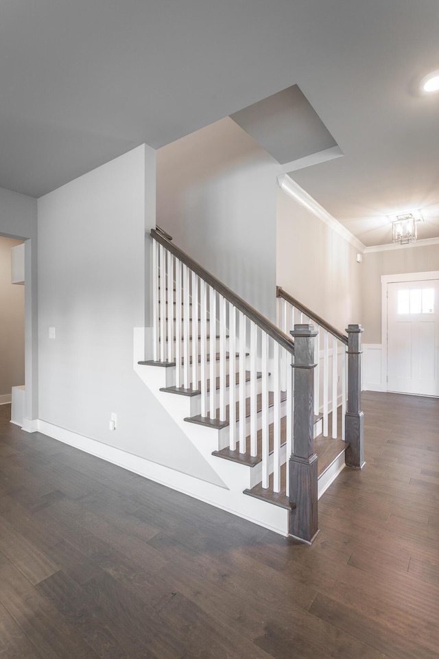 stairs featuring an inviting chandelier and wood-type flooring