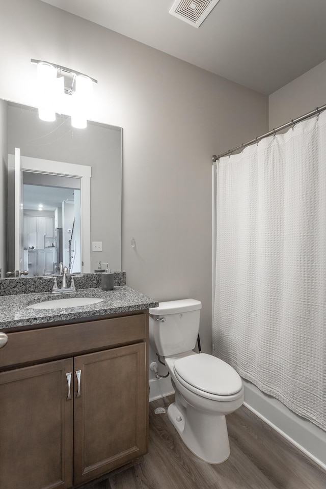 bathroom with an inviting chandelier, toilet, vanity, and hardwood / wood-style flooring