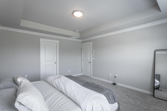 bedroom with a raised ceiling, ornamental molding, and carpet flooring