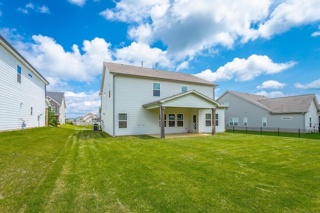 rear view of property with a patio and a lawn