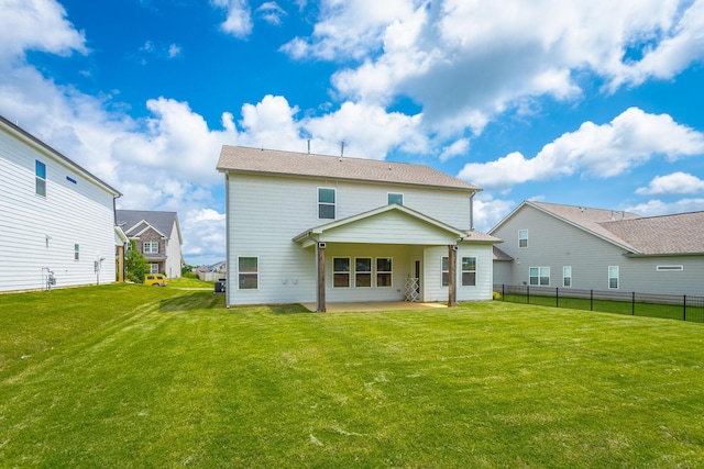 rear view of property featuring a yard and a patio