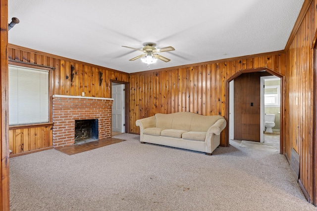 living room featuring ceiling fan, light colored carpet, and a fireplace