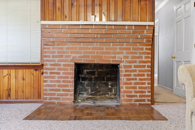 room details featuring a brick fireplace, ornamental molding, and carpet