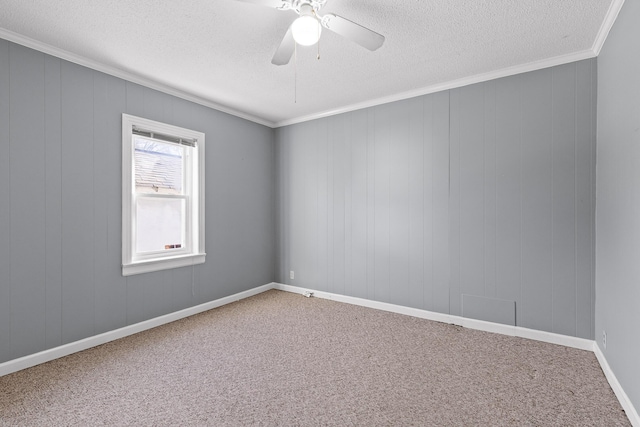 carpeted spare room featuring a textured ceiling, ceiling fan, crown molding, and wooden walls