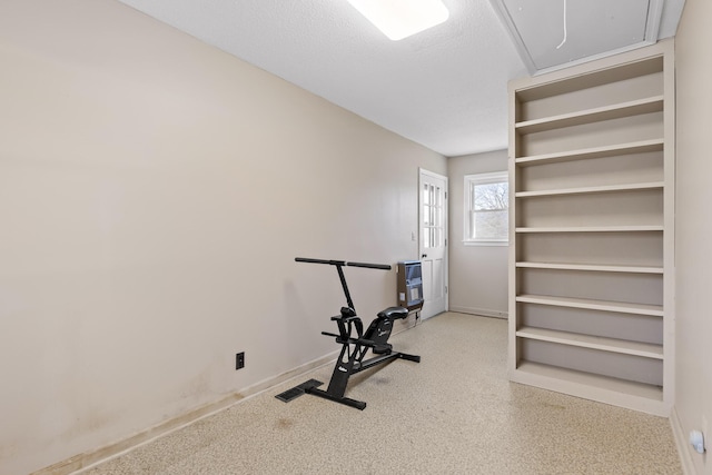 exercise area with heating unit and a textured ceiling