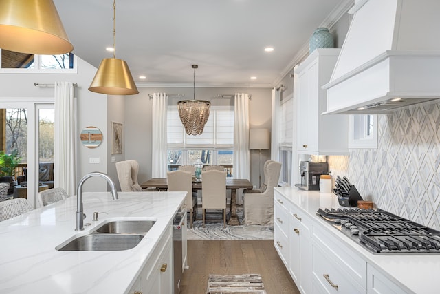 kitchen featuring white cabinets, custom range hood, appliances with stainless steel finishes, dark wood-type flooring, and a sink