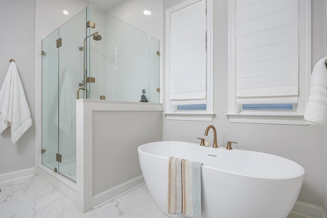 bathroom featuring marble finish floor, baseboards, a soaking tub, and a marble finish shower