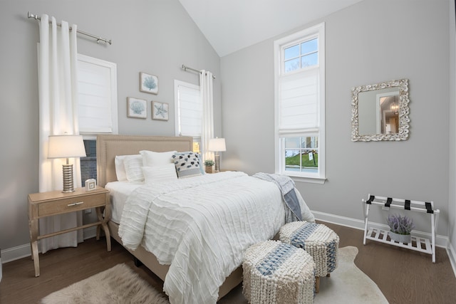 bedroom with multiple windows, vaulted ceiling, and wood finished floors