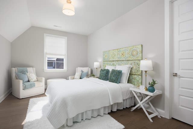 bedroom featuring vaulted ceiling, wood finished floors, visible vents, and baseboards