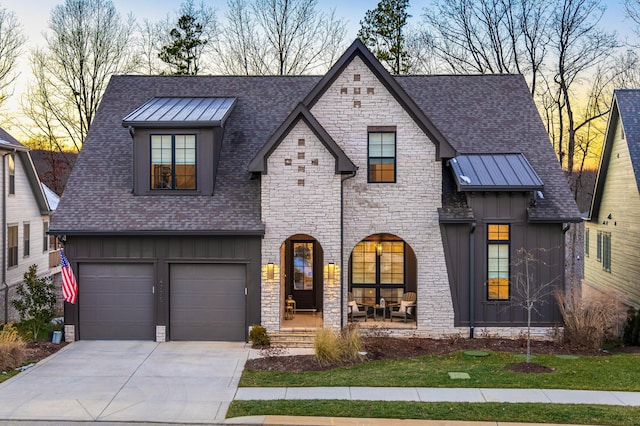 view of front of property with covered porch, roof with shingles, board and batten siding, and concrete driveway