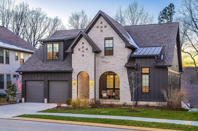 view of front of property featuring board and batten siding, stone siding, and a garage