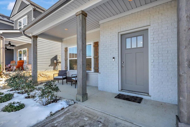 snow covered property entrance with a porch