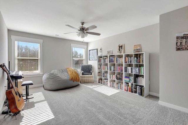 living area featuring ceiling fan and light colored carpet