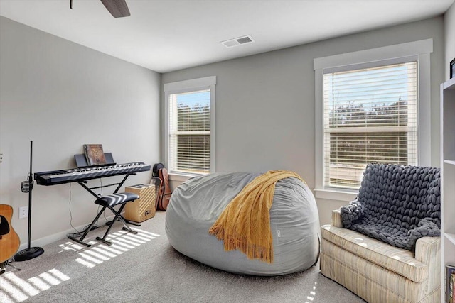 living area featuring ceiling fan and carpet flooring