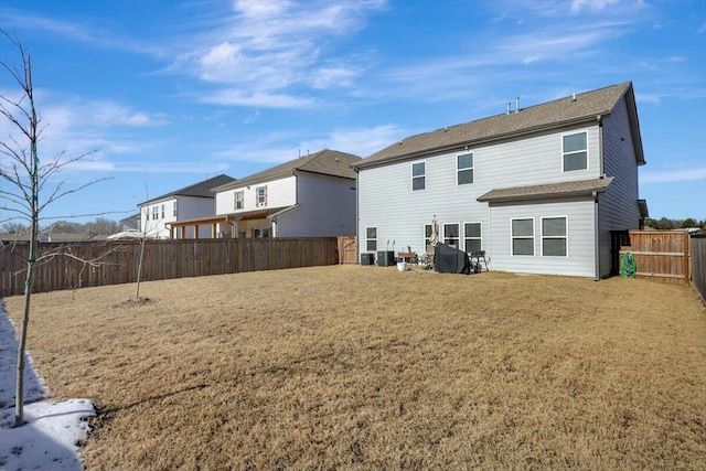 rear view of property with central AC unit and a yard