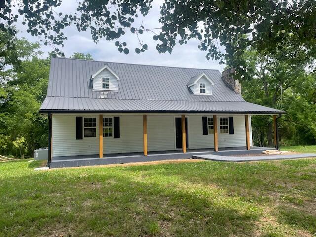 country-style home featuring a porch and a front yard