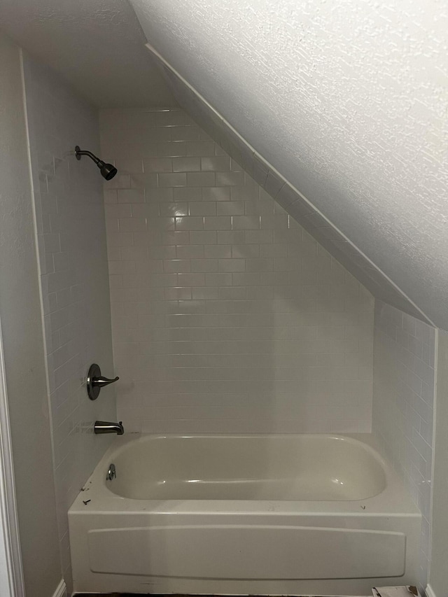 bathroom featuring a textured ceiling and shower / bathtub combination