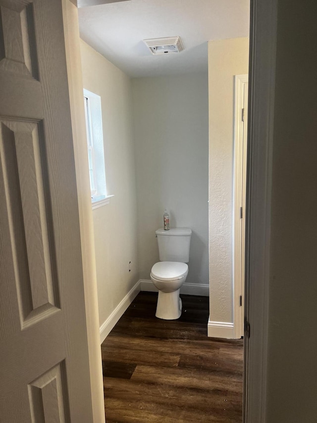 bathroom featuring toilet and wood-type flooring