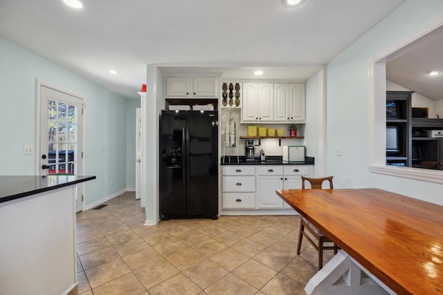 kitchen with black refrigerator with ice dispenser, white cabinetry, and light tile patterned floors