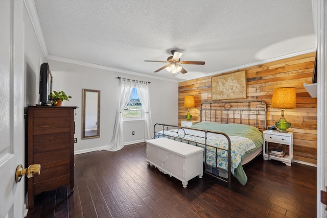 bedroom with wood walls, ceiling fan, ornamental molding, and dark wood-type flooring