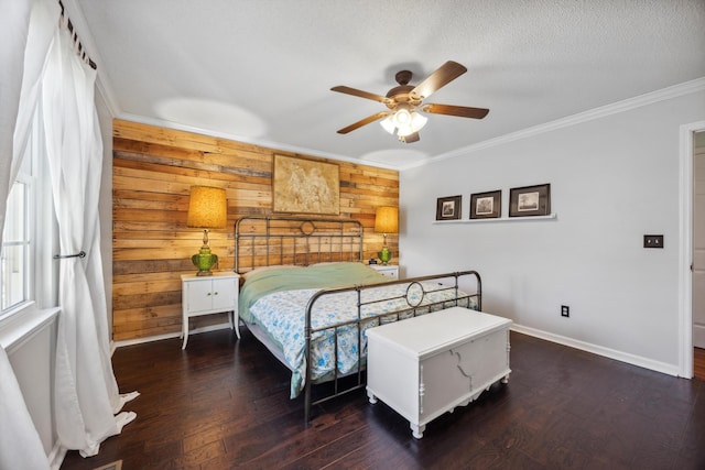 bedroom with ceiling fan, wooden walls, crown molding, and dark hardwood / wood-style floors