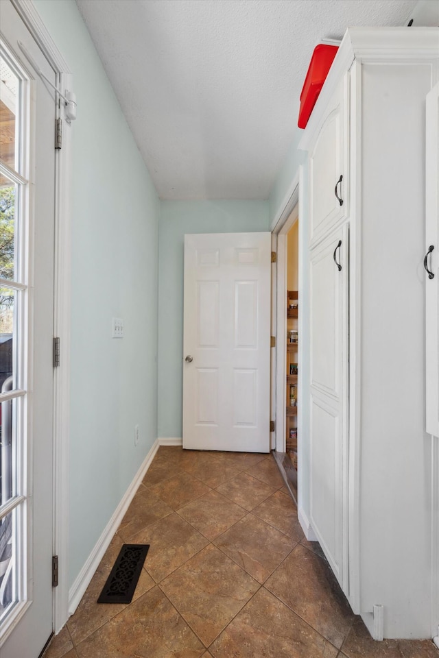 hallway featuring dark tile patterned flooring