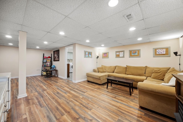 living room with hardwood / wood-style flooring, separate washer and dryer, and a paneled ceiling