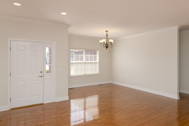 entryway featuring an inviting chandelier, crown molding, and dark hardwood / wood-style flooring