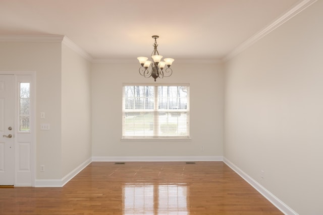 unfurnished room featuring a chandelier, hardwood / wood-style flooring, and ornamental molding