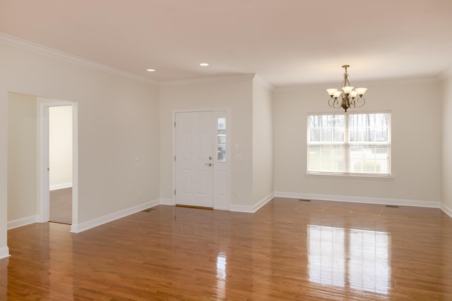 foyer with a notable chandelier, crown molding, and hardwood / wood-style flooring