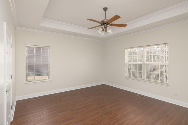 spare room with dark hardwood / wood-style flooring, ceiling fan, a tray ceiling, and crown molding