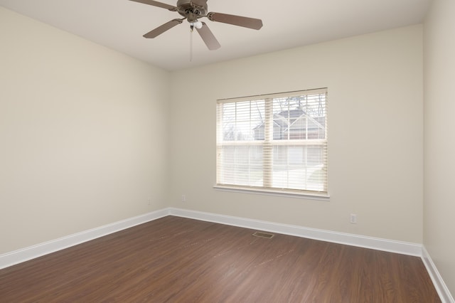 spare room with dark hardwood / wood-style flooring and ceiling fan