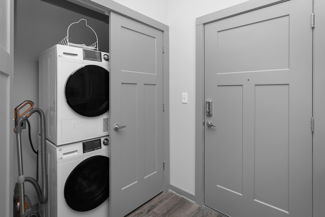 washroom featuring dark hardwood / wood-style flooring and stacked washer and dryer