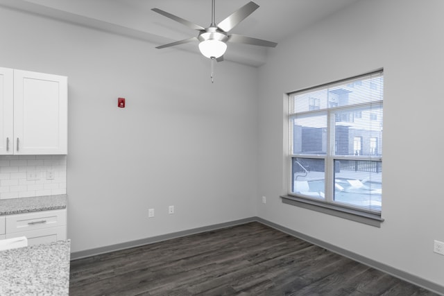 unfurnished dining area with plenty of natural light, dark hardwood / wood-style floors, and ceiling fan