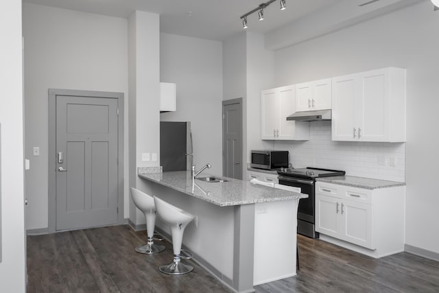 kitchen with kitchen peninsula, white cabinets, sink, and appliances with stainless steel finishes