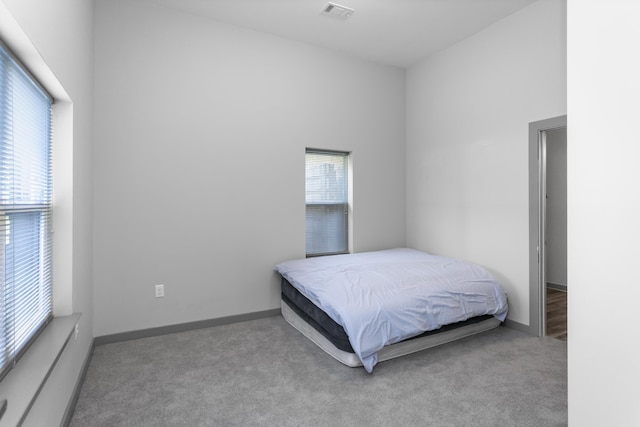 carpeted bedroom with a high ceiling