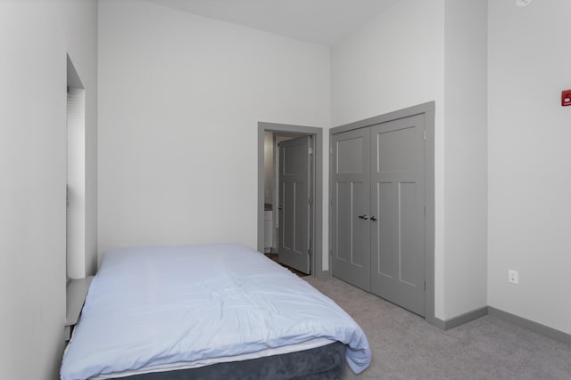 bedroom featuring light colored carpet and a closet