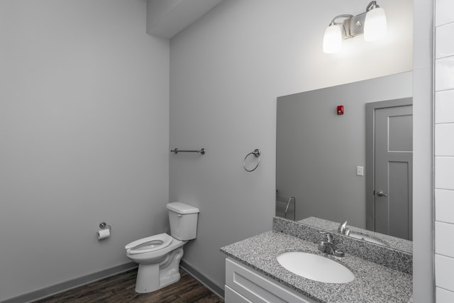 bathroom with vanity, toilet, and wood-type flooring