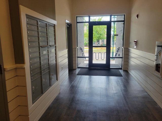 entryway with dark wood-type flooring and a mail area