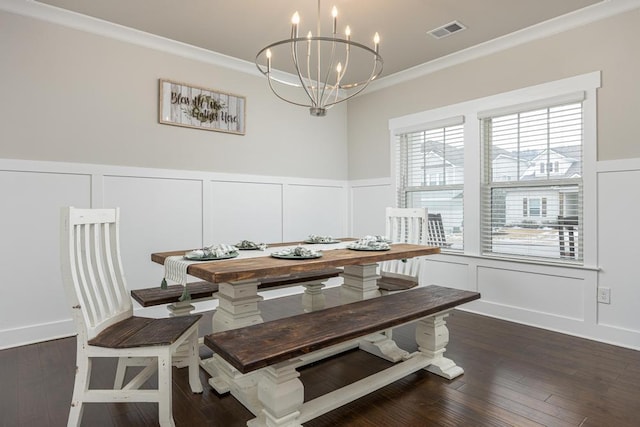 dining space featuring crown molding, dark wood-type flooring, and an inviting chandelier