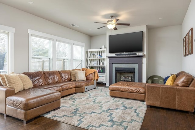 living room featuring ceiling fan and dark hardwood / wood-style floors