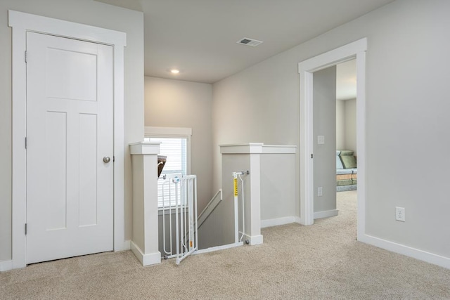 hall featuring light colored carpet