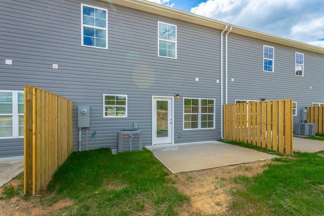 back of property with a patio and central AC