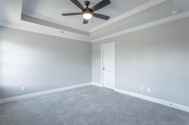 carpeted empty room with ceiling fan, a tray ceiling, and crown molding