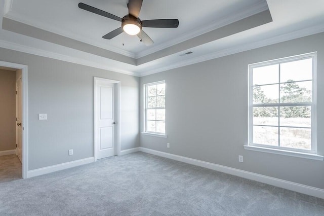 unfurnished room featuring ornamental molding, ceiling fan, carpet, and a tray ceiling