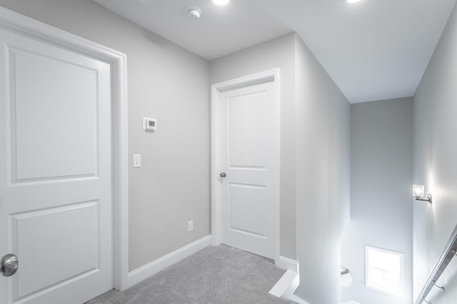 hallway featuring light colored carpet