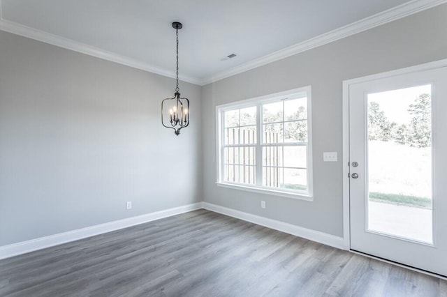 unfurnished dining area with an inviting chandelier, crown molding, and wood-type flooring