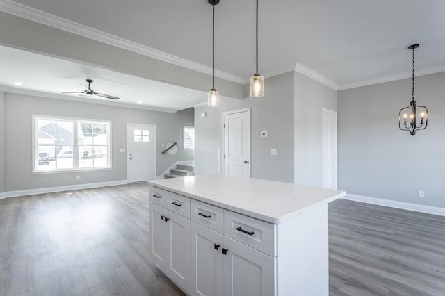 kitchen with ceiling fan with notable chandelier, white cabinets, hanging light fixtures, and dark wood-type flooring