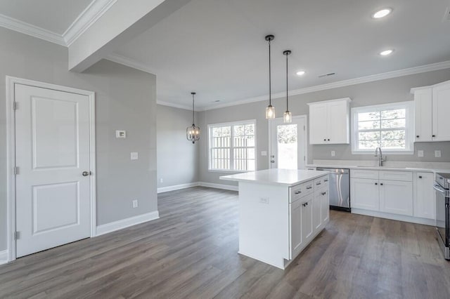 kitchen with a kitchen island, stainless steel appliances, hanging light fixtures, and white cabinetry